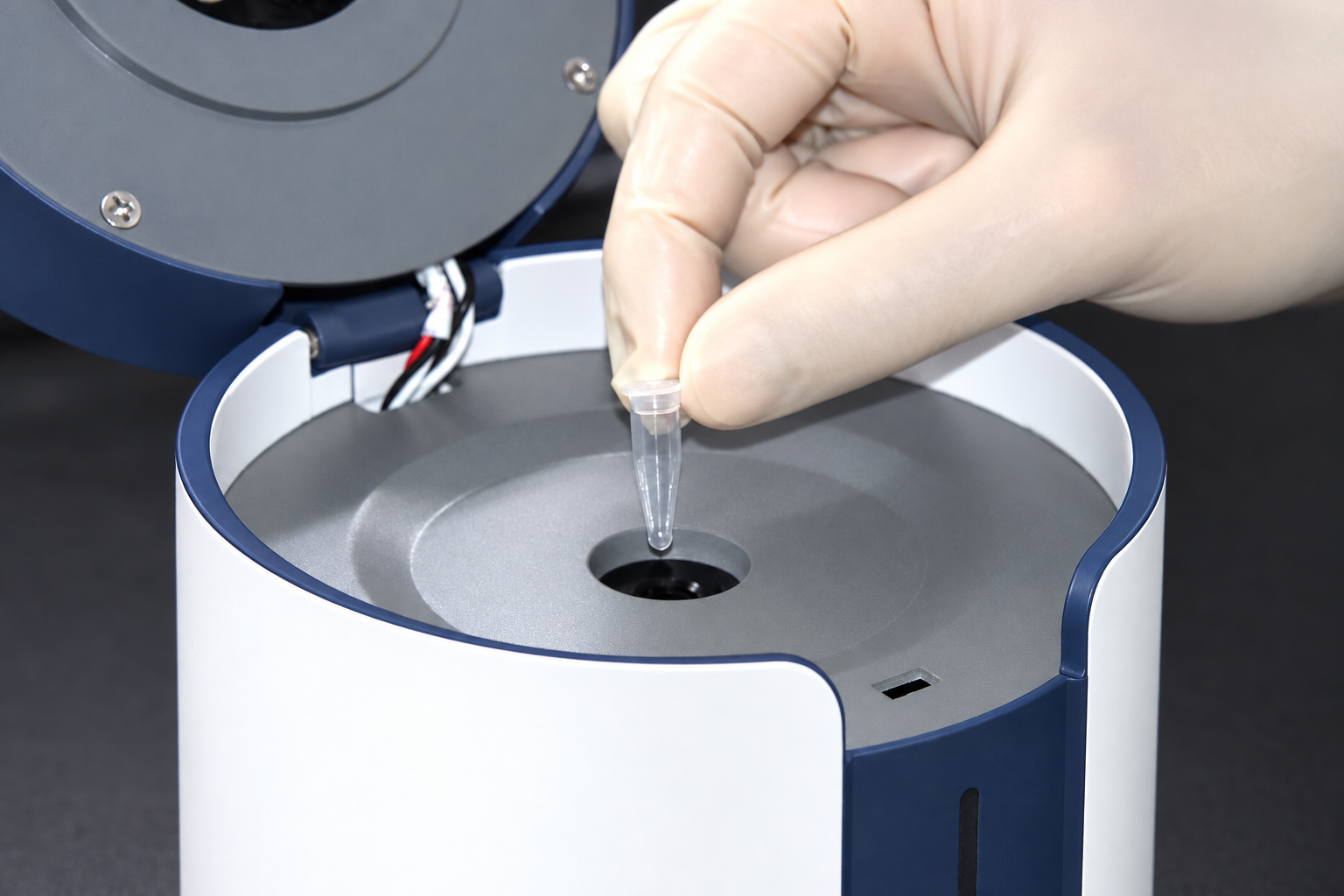 Gloved hand placing one clear PCR tube into the central YS-M4 sample well